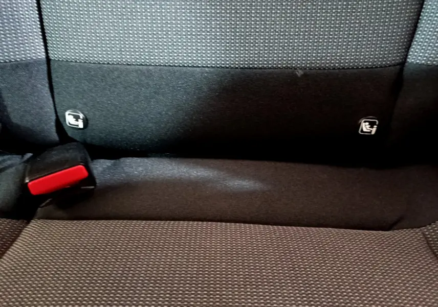 Gros plan sur la banquette arrière noire de la Citroën C3 avec fixation Isofix et boucle de ceinture rouge visible.