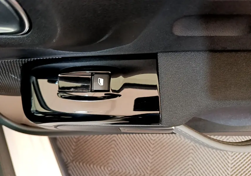 Gros plan sur la commande de lève-vitre côté conducteur de la Citroën C3 blanche, finition Shine Business.