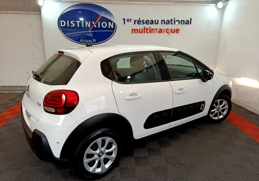 Citroën C3 blanche vue 3/4 arrière droit avec protections latérales noires et jantes argentées.