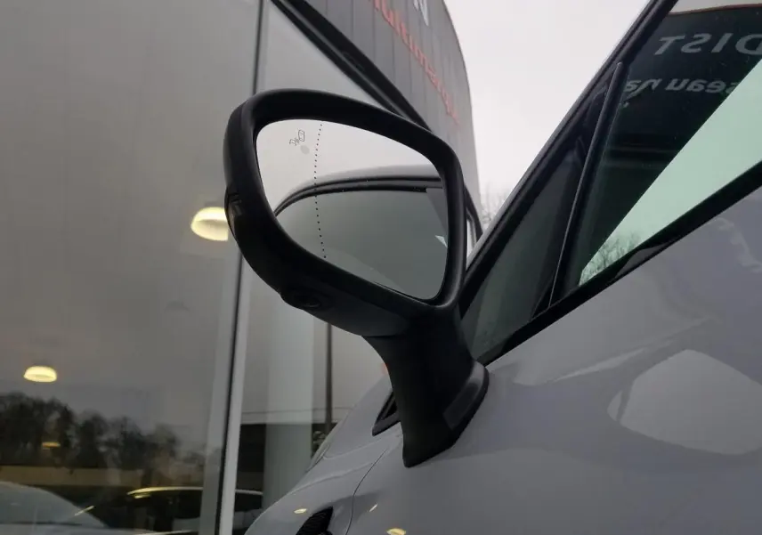 Rétroviseur côté gauche noir brillant du Renault Captur gris Rafale 2025, vue rapprochée sur la portière avant.