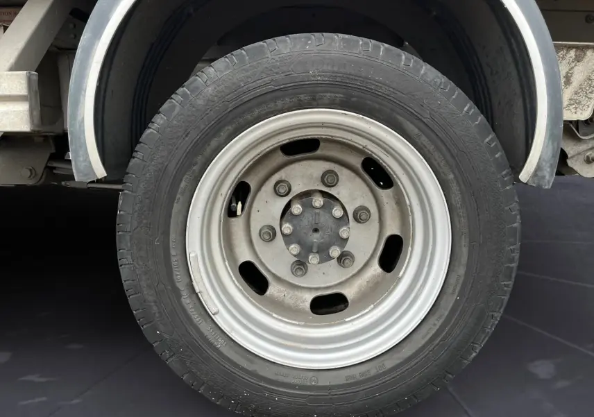 Gros plan sur la roue jumelée arrière droite du Renault Master Châssis Cabine blanc avec benne et coffre.