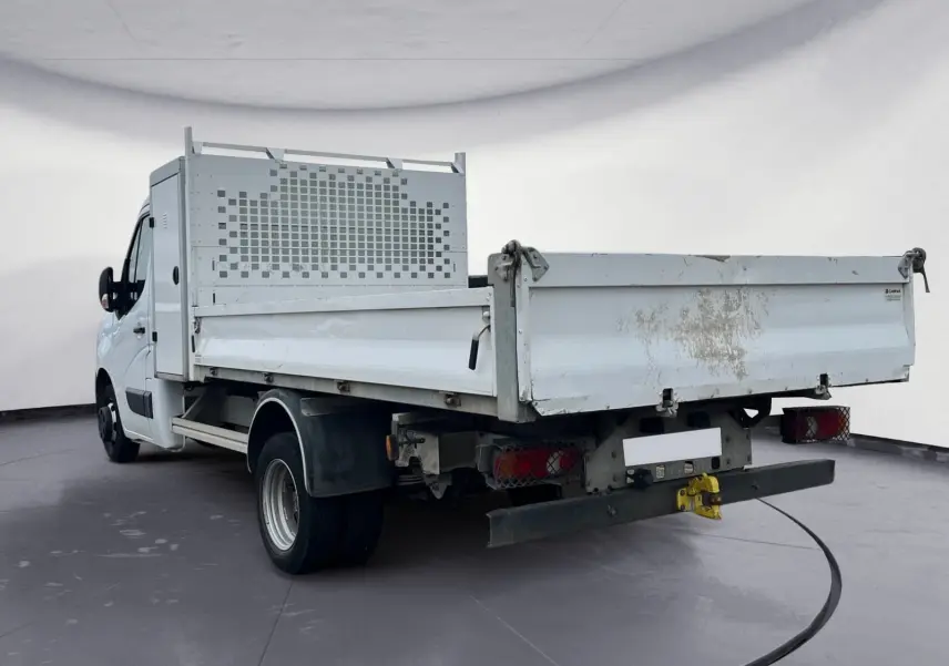 Vue 3/4 arrière droite d’un Renault Master Châssis Cabine blanc avec benne et coffre, roues jumelées et pare-éclats métallique.