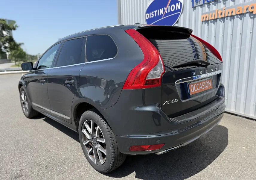 Vue 3/4 arrière droit d'un Volvo XC60 gris foncé avec feux arrière LED et jantes alliage 19 pouces biton.