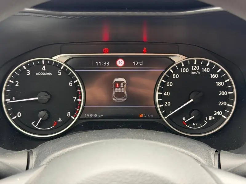 Tableau de bord du Nissan Juke 2025 avec compte-tours, vitesse, écran multifonction et alertes ouvertes portes.