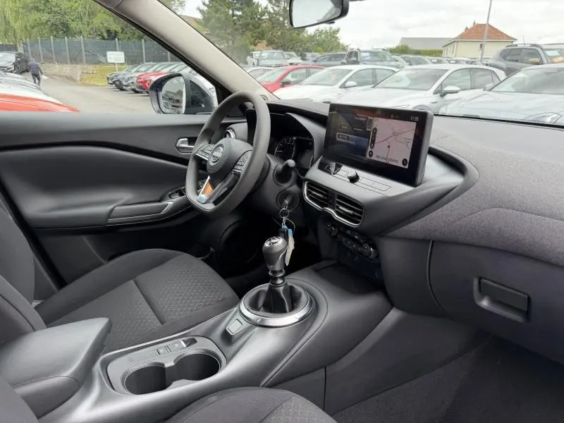 Intérieur du Nissan Juke 2025 vu côté conducteur, volant multifonction et écran tactile avec navigation visible.