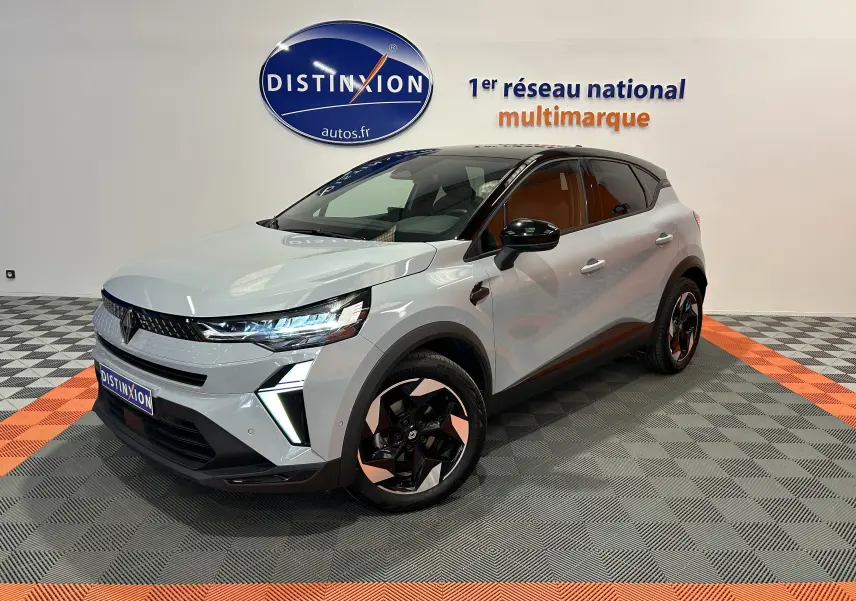 Renault Captur II Ph.2 gris Rafale en 3/4 avant droit, avec jantes bicolores et feux LED allumés.