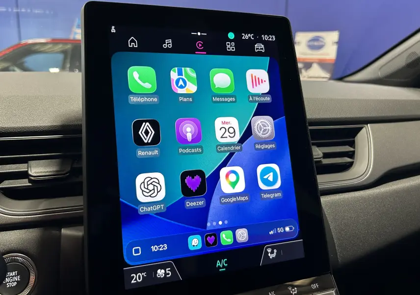 Écran tactile central vertical du Renault Captur gris rafale, affichant plusieurs applications connectées, vue intérieure avant.
