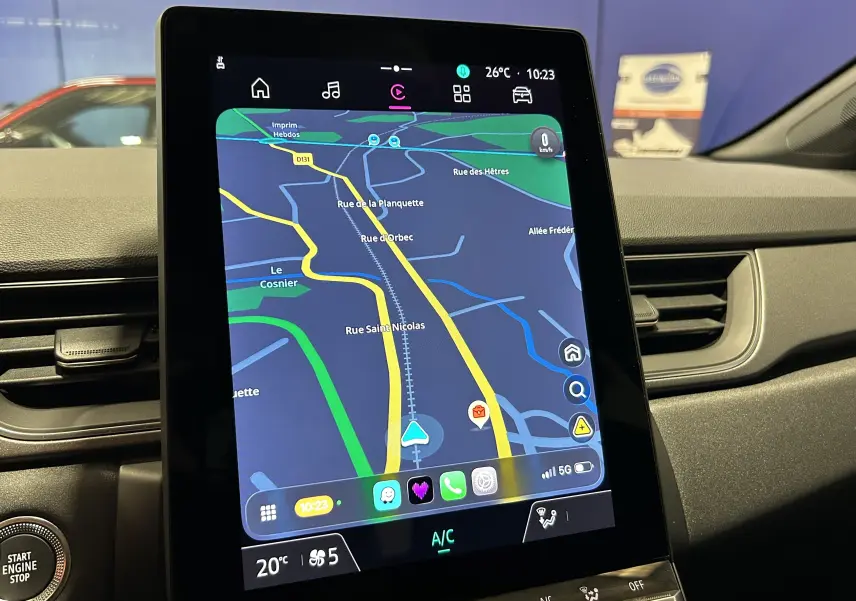 Vue intérieure du tableau de bord du Renault Captur gris Rafale, mettant en valeur l'écran tactile central avec navigation active.