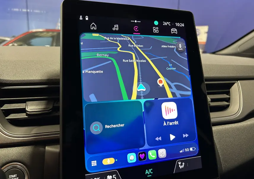 Écran tactile central du Renault Captur gris Rafale, affichant la navigation et les commandes multimédias, vue intérieure frontale.