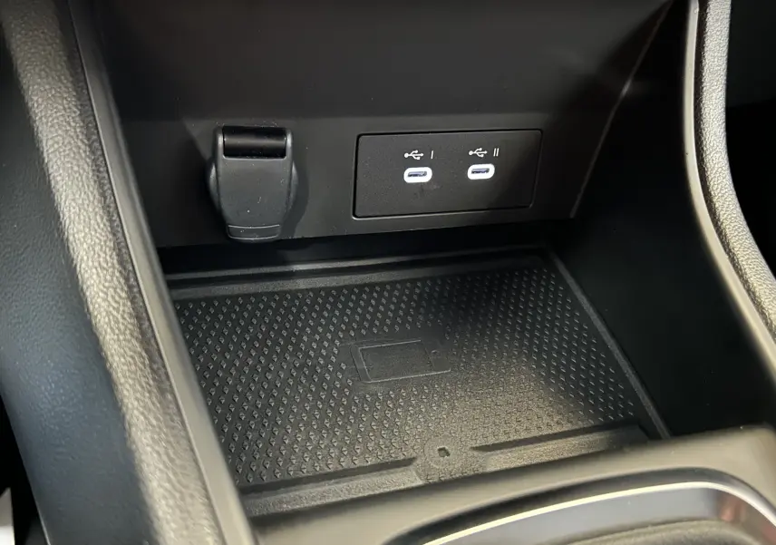 Gros plan sur la console centrale noire du Renault Captur II Ph.2 avec deux ports USB-C lumineux et un espace de rangement antidérapant.