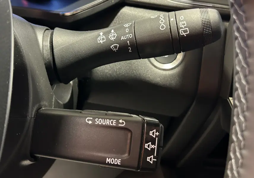 Gros plan sur les commandes de la colonne de direction du Renault Captur gris Rafale, avec boutons source et essuie-glace.