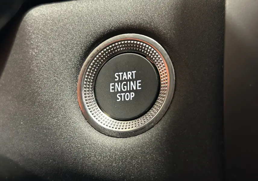 Bouton Start Engine Stop en gros plan sur le tableau de bord noir du Renault Captur gris Rafale 2025.
