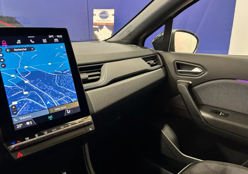 Vue intérieure côté passager du Renault Captur gris Rafale 2025, avec écran tactile affichant la navigation.