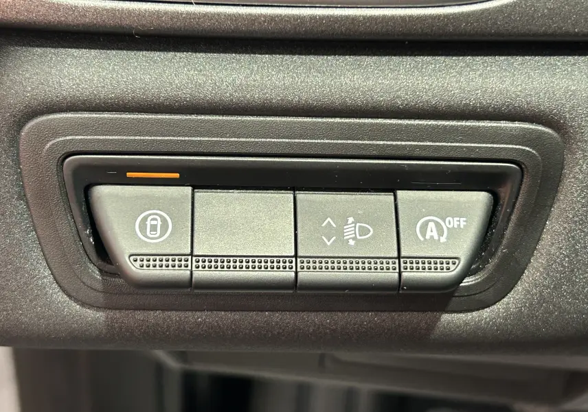 Gros plan sur les boutons de commande du tableau de bord du Renault Captur gris Rafale, avec réglage phares et arrêt auto-start.