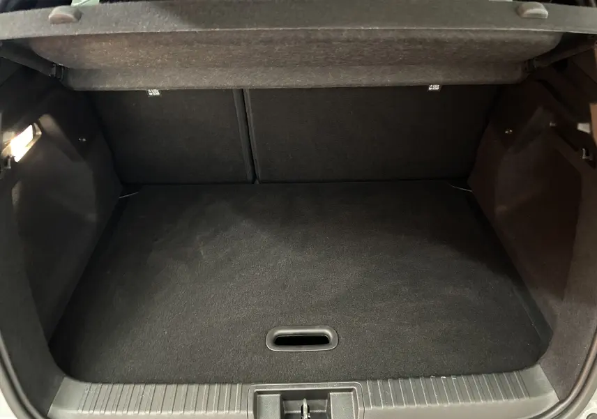Coffre ouvert vu de face du Renault Captur gris Rafale, montrant un espace de rangement propre et bien fini.