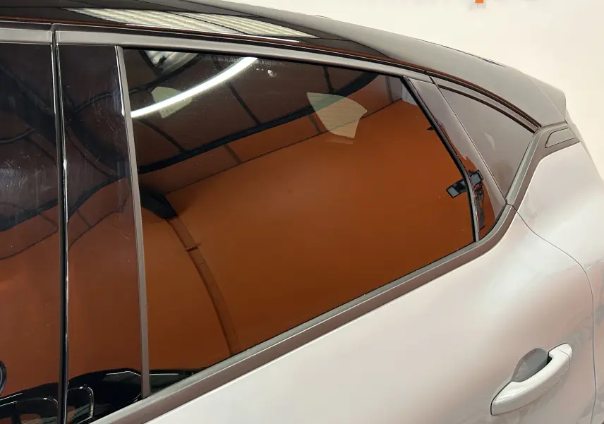 Vue rapprochée du côté arrière droit du Renault Captur gris Rafale, mettant en valeur la vitre teintée et la poignée de porte.