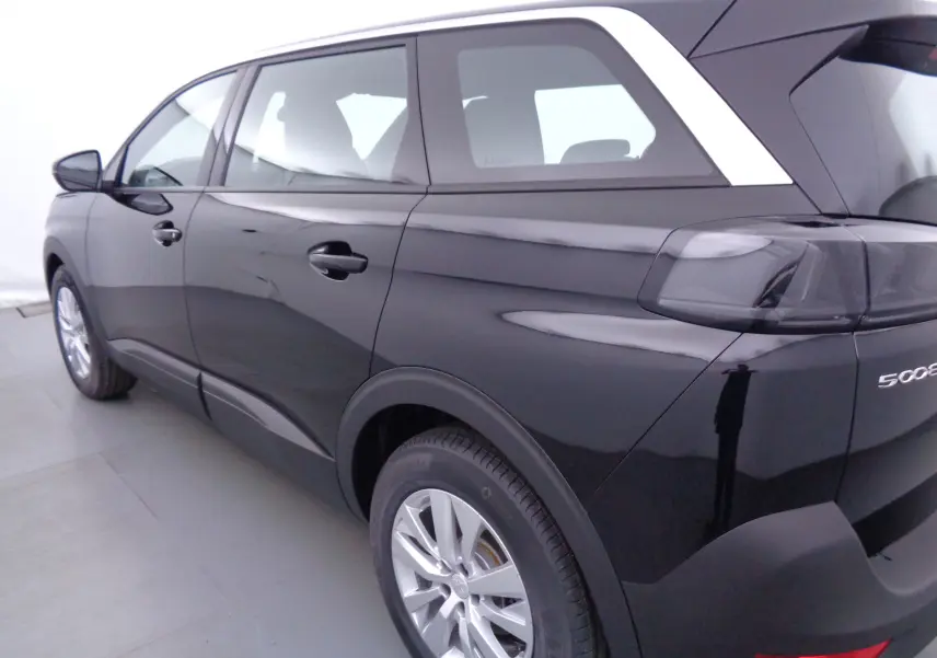 Vue 3/4 arrière droit du Peugeot 5008 noir perle métal avec jantes alliage et feux arrière fumés.