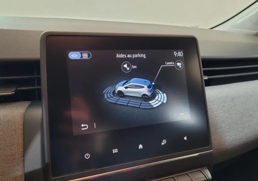 Écran tactile central montrant l'aide au parking avec représentation 3D d'une Renault Clio bleue vue de dessus côté droit.