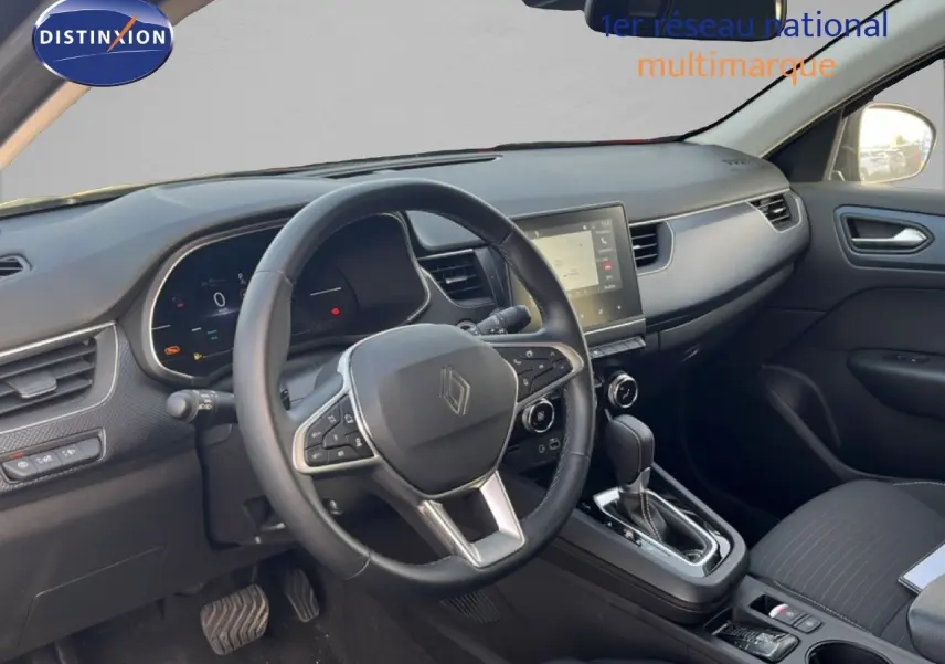 Vue intérieure du poste de conduite de la Renault Arkana gris satin métal, avec volant multifonction et écran tactile central.