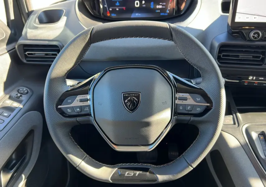 Vue rapprochée du volant cuir multifonctions Peugeot Rifter GT Plus 2025 avec logo et commandes intégrées.