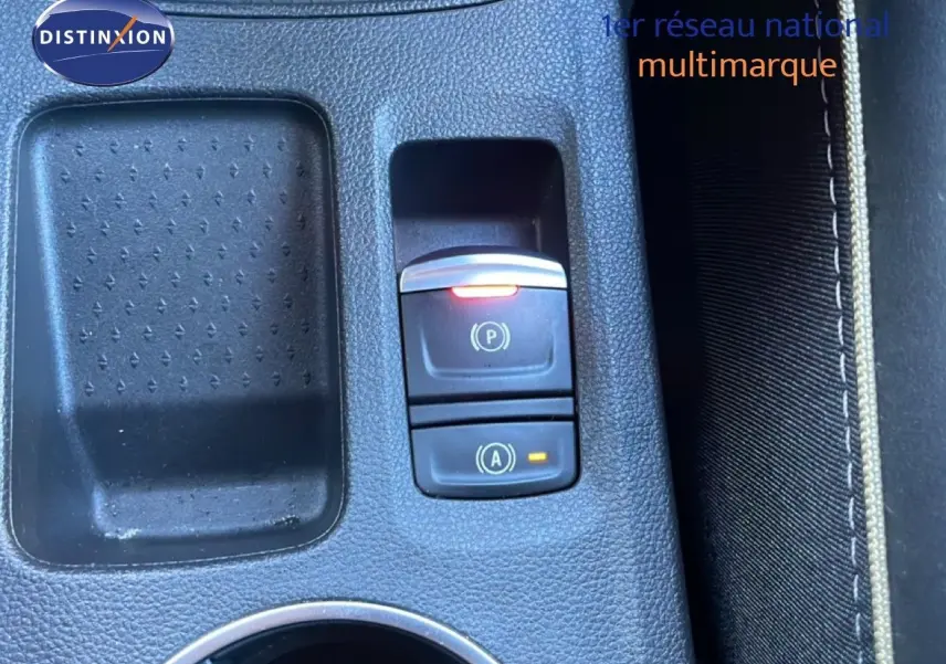 Gros plan sur la console centrale noire avec commandes électroniques du frein à main et du système start-stop du Renault Symbioz.