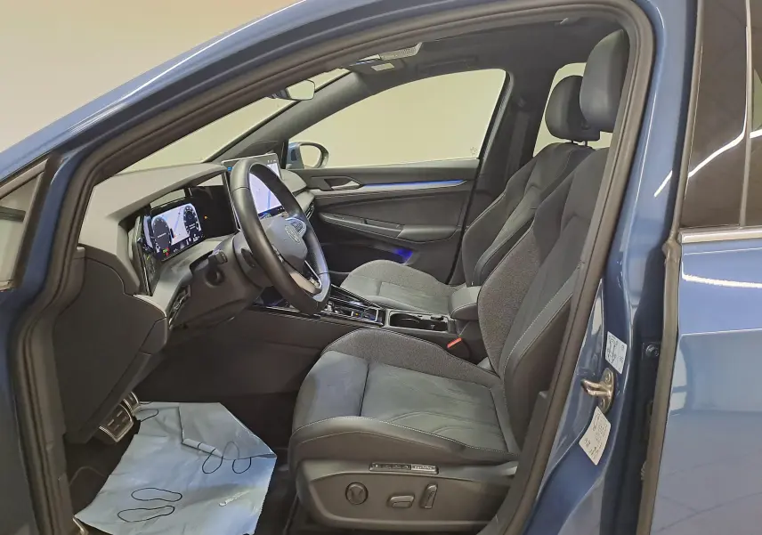 Vue intérieure côté conducteur de la Volkswagen Golf 1.5 eTSI 150 DSG7 Bleu Anémone avec sièges sport et tableau de bord digital.