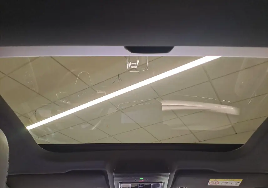 Vue intérieure du toit ouvrant panoramique de la Volkswagen Golf 1.5 eTSI Bleu Anémone avec commandes intégrées au plafond.