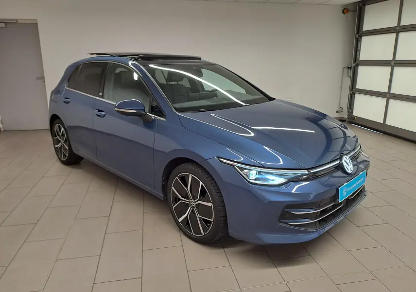 Volkswagen Golf 1.5 eTSI 150 bleu Anémone vue 3/4 avant avec toit ouvrant panoramique et phares Matrix LED allumés.