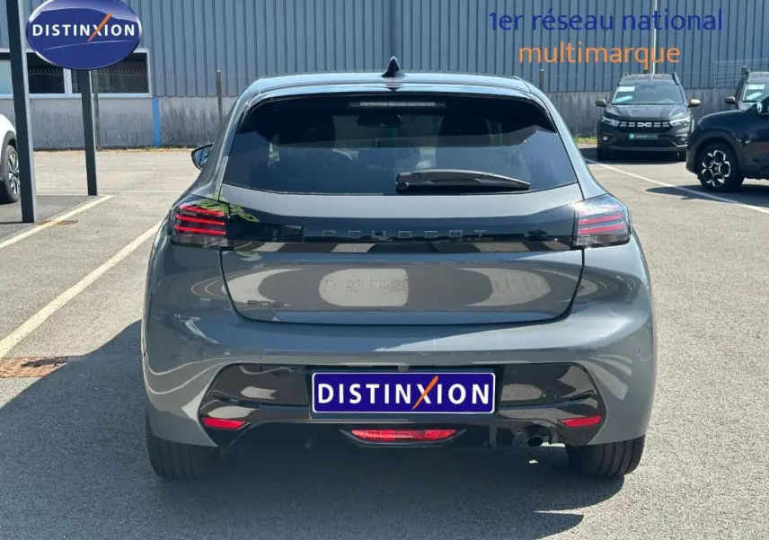 Vue arrière d'une Peugeot 208 gris Selenium 2025 avec feux LED et logo Peugeot en relief sur le hayon.
