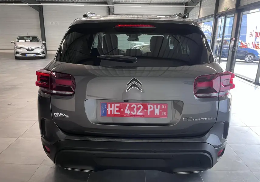 Vue arrière du Citroën C5 Aircross gris platinium avec feux arrière LED et double sortie d'échappement visible en showroom.