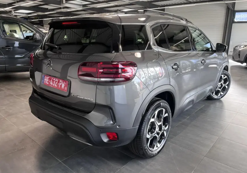 Vue 3/4 arrière droit du Citroën C5 Aircross gris platinium avec jantes alliage bi-ton et vitres surteintées.