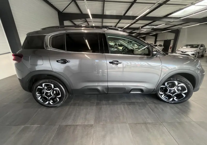 Vue de profil côté gauche d'un Citroën C5 Aircross gris platinium avec jantes alliage bi-ton et vitres surteintées.
