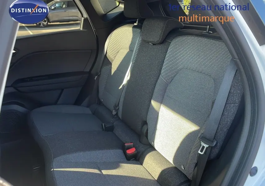 Vue intérieure sur la banquette arrière grise du Renault Captur blanc nacré avec ceinture de sécurité et porte ouvert côté droit.