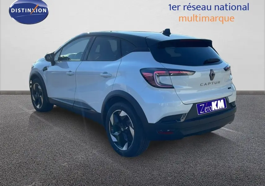 Vue 3/4 arrière droite d'un Renault Captur blanc nacré avec toit noir, mettant en valeur ses feux LED et jantes bi-ton.