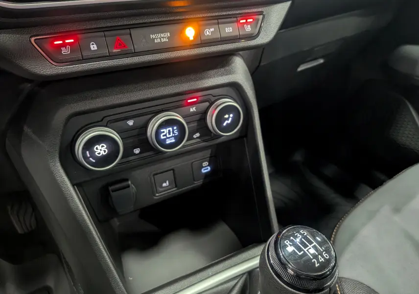 Gros plan sur la console centrale et levier de vitesse manuelle du Dacia Sandero Stepway 2025, avec commandes clim et sièges chauffants.