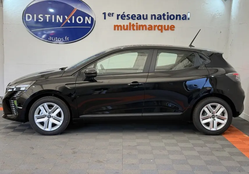 Profil côté gauche d'une Renault Clio noire 2025 garée en intérieur avec jantes argentées et antenne sur le toit.