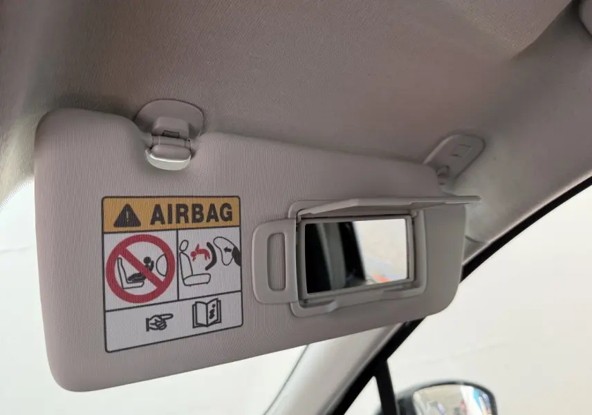 Détail du pare-soleil côté conducteur avec miroir et avertissement airbag dans une Renault Clio noire 2025.