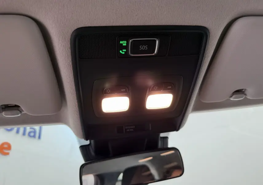 Plafonnier intérieur allumé avec bouton SOS et miroir rétro central d'une Renault Clio noire 2025 vue de dessous.