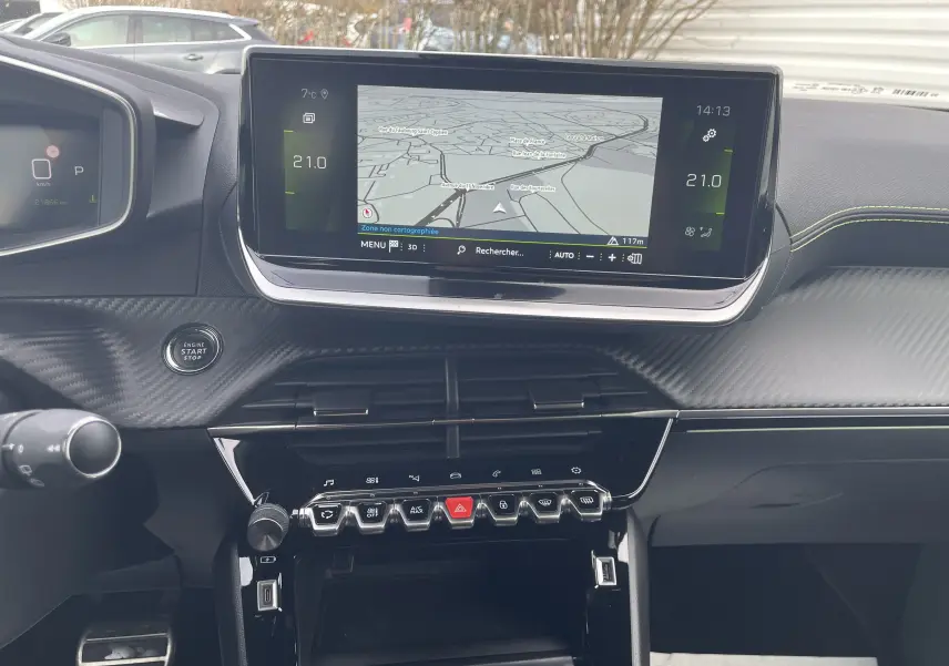 Vue intérieure du tableau de bord du Peugeot 2008 gris Artense, avec écran tactile central affichant la navigation et commandes tactiles en dessous.