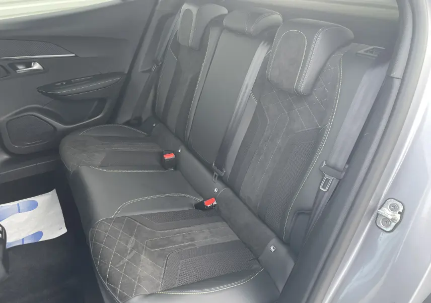 Vue intérieure côté droit des sièges arrière en cuir et alcantara noir avec surpiqûres vertes du Peugeot 2008 gris Artense 2022.