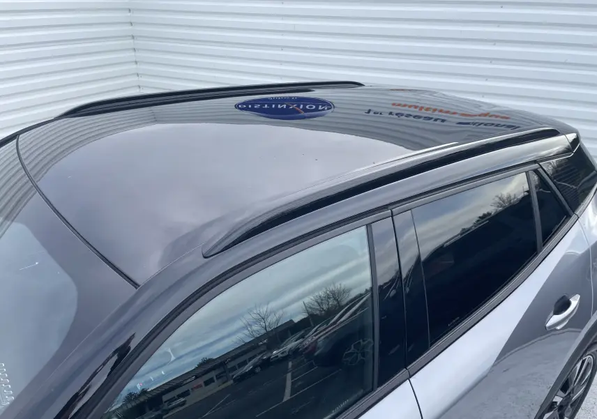 Vue en plongée du toit noir brillant et des vitres teintées côté droit du Peugeot 2008 gris Artense 2022.