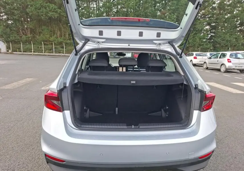 Vue arrière du coffre ouvert d'une Skoda Fabia Ambition gris argent 2023, montrant l'espace de chargement vide.