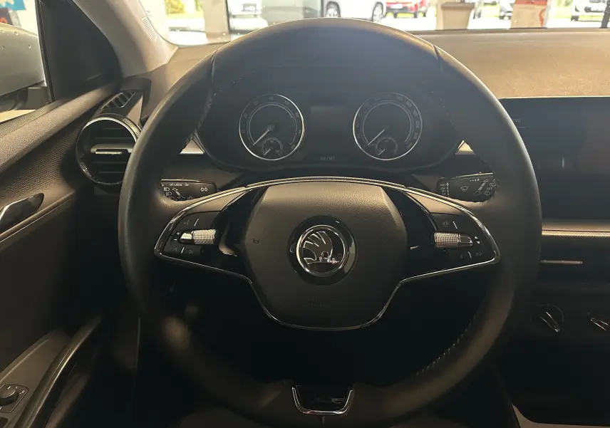 Vue frontale du volant noir de la Skoda Fabia Ambition 2023 avec tableau de bord et commandes intégrées.