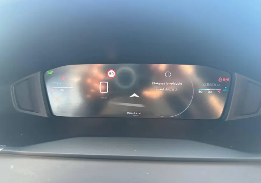 Tableau de bord numérique de Peugeot 208 2025 affichant un message d'arrêt et la vitesse à 0 km/h.