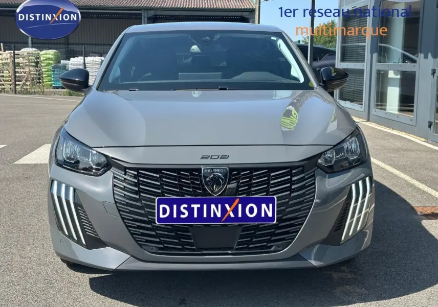 Vue avant d'une Peugeot 208 2025 gris Selenium avec calandre noire et feux LED verticaux distinctifs.