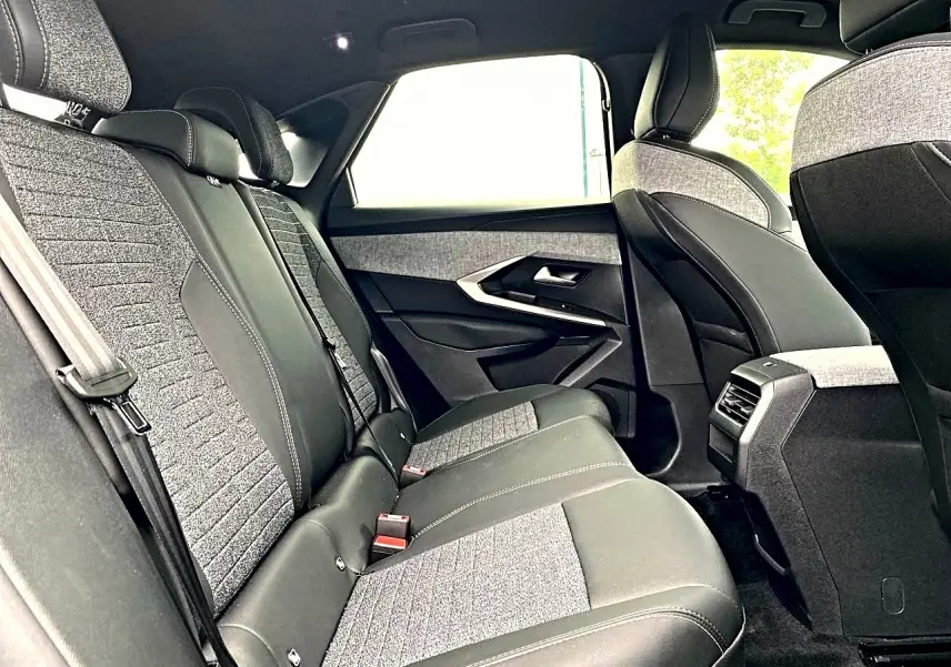 Vue intérieure arrière côté droit du Peugeot 3008 1.2 hybrid 145 allure 2025, sièges bi-matière gris et noir.