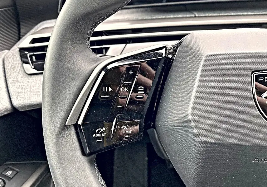 Gros plan sur le volant cuir multifonction côté gauche du Peugeot 3008 2025, avec commandes d'assistance et régulateur.