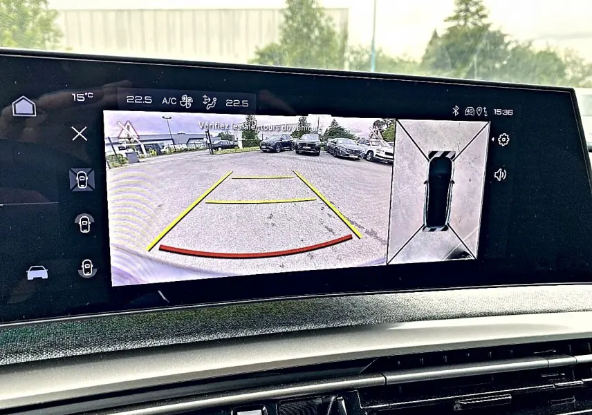 Écran tactile intérieur du Peugeot 3008 bleu 2025 montrant la caméra de recul et vue 360° du véhicule en stationnement.