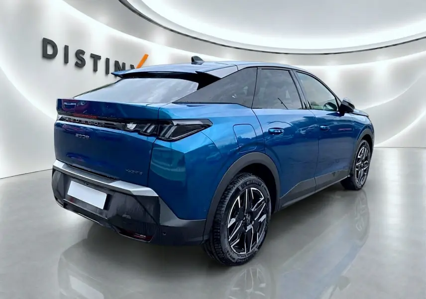 Peugeot 3008 bleu 3/4 arrière droit, avec jantes alu noires et toit noir contrasté dans un showroom lumineux.