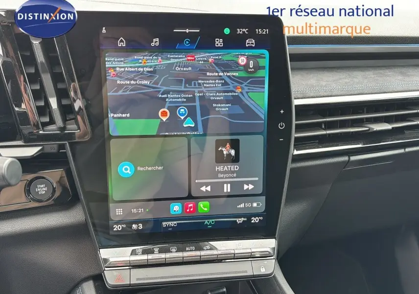 Tableau de bord du Renault Austral 2024 avec écran tactile vertical affichant navigation et musique, finition intérieure noire.